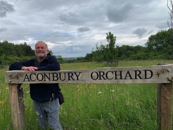 Paul Snookes leaning against orchard sign